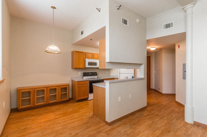 an empty kitchen with wood flooring and white walls