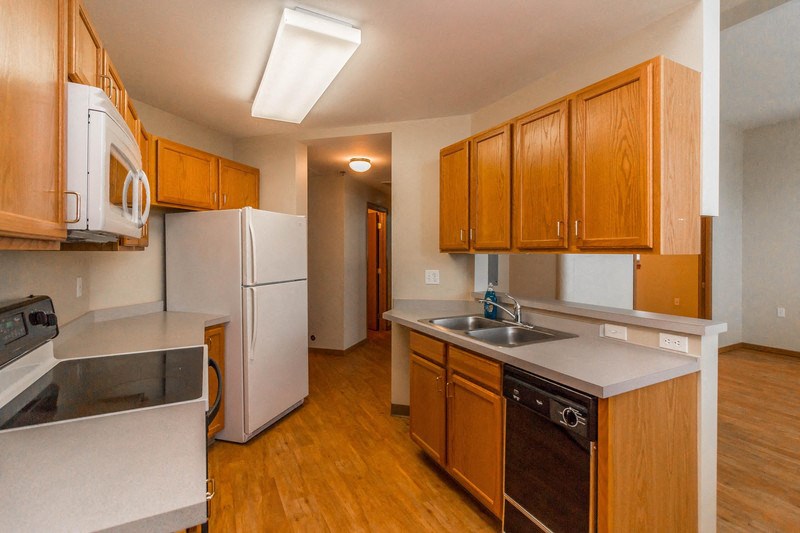 a kitchen with white appliances and wooden cabinets