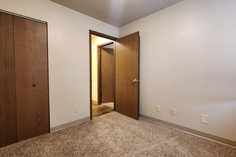 a bedroom with two doors and a carpeted floor
