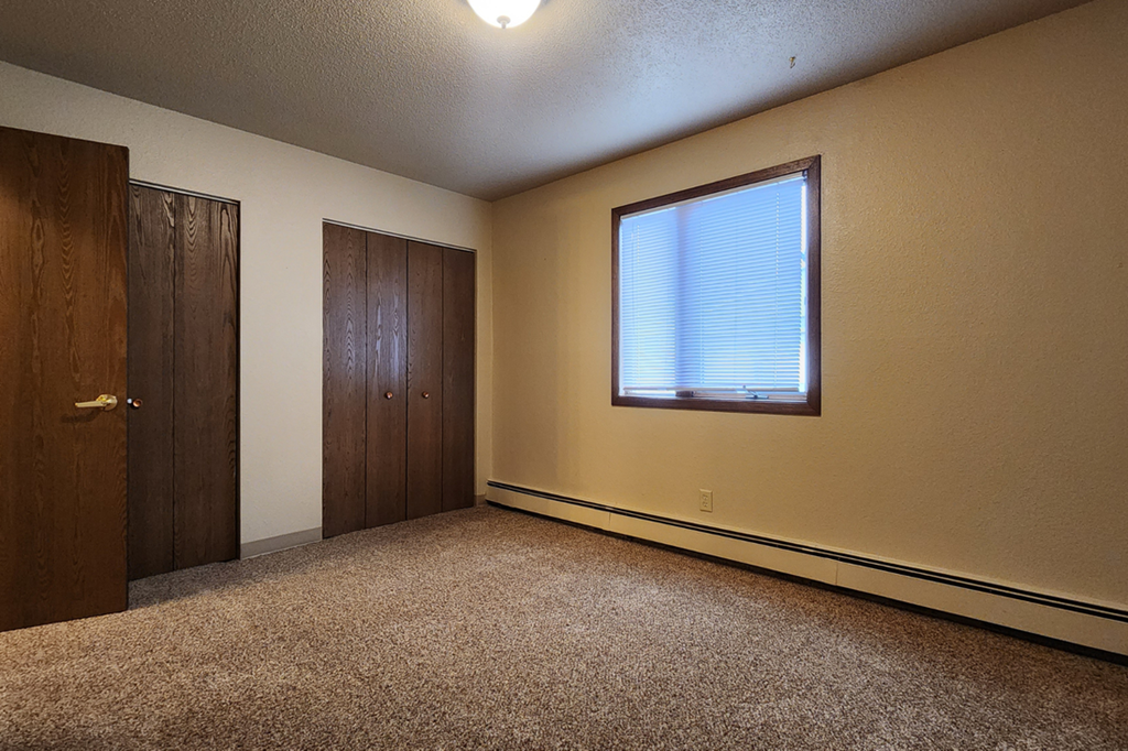 an empty room with a window and a door