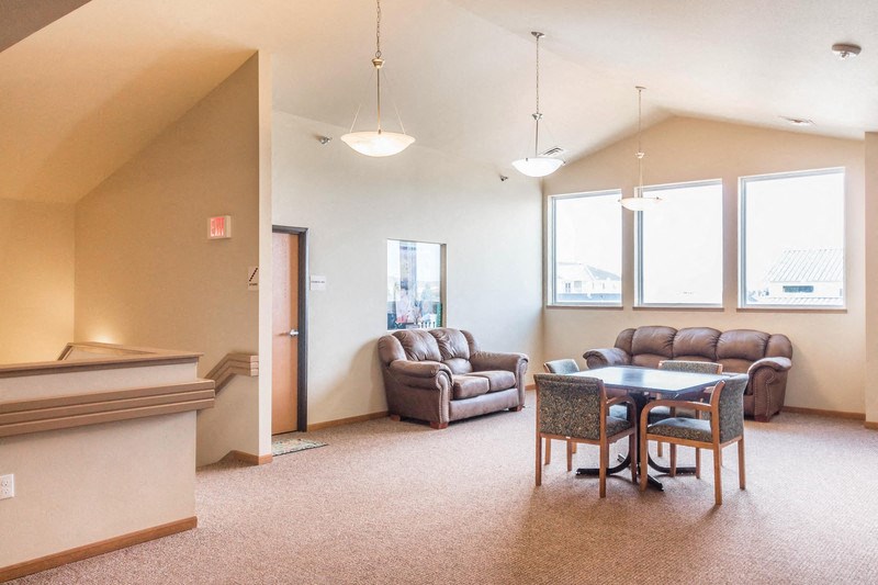 a living room with couches and a table and chairs