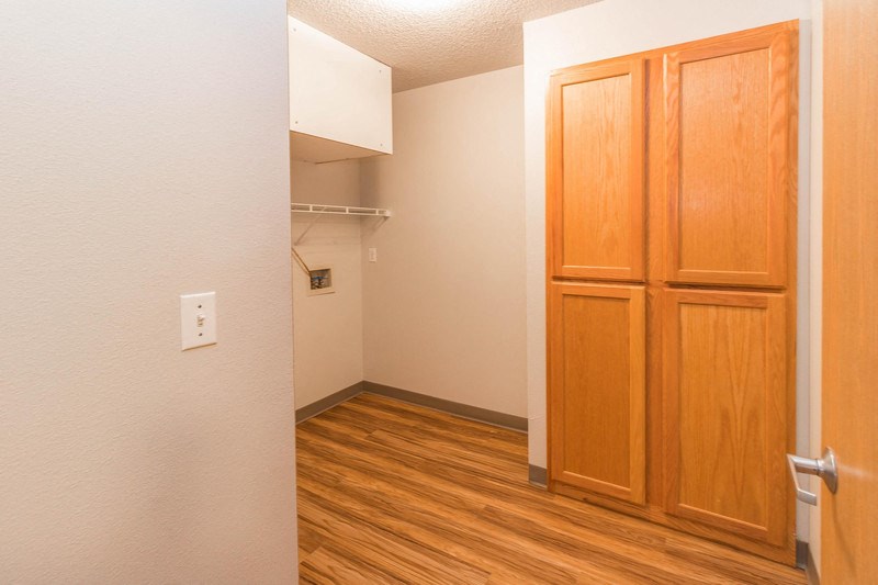 a bedroom with wooden floors and a closet