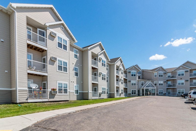 an empty street with an apartment building on the side