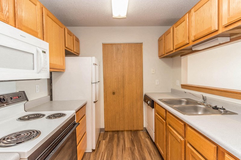 a kitchen with white appliances and wooden cabinets
