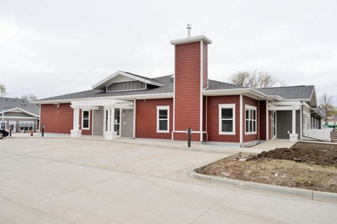 the front of a red building with a parking lot