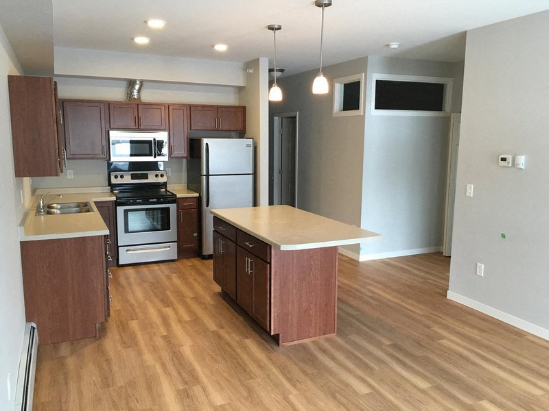 a kitchen with wooden floors and stainless steel appliances