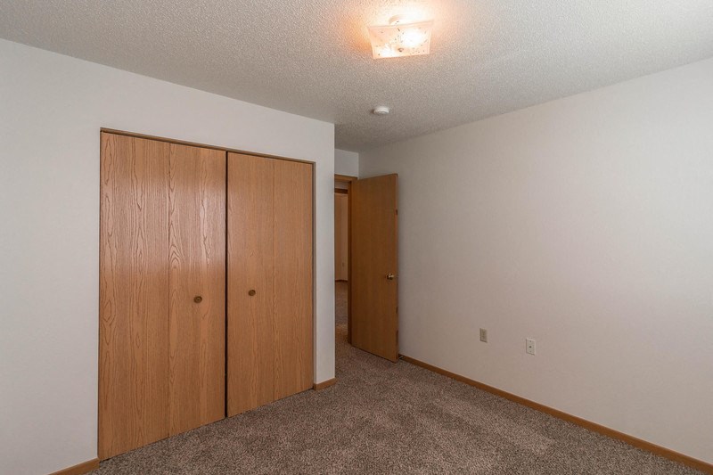 a bedroom with a closet and a door to a hallway