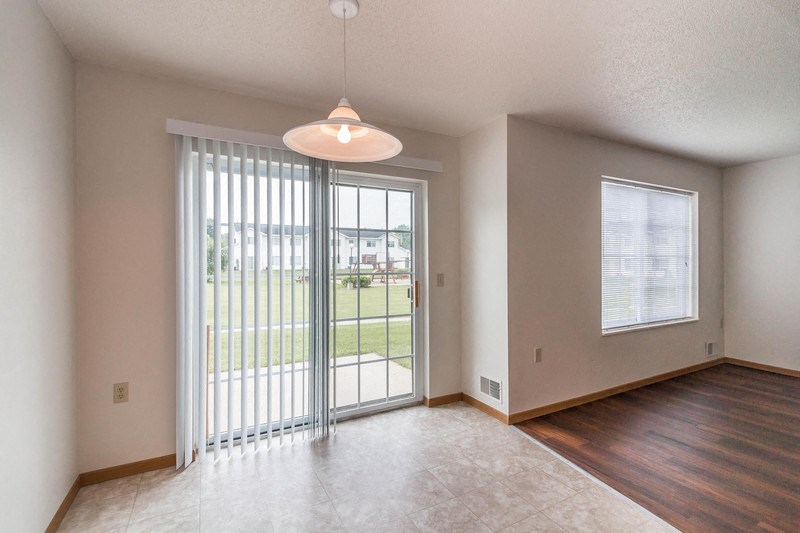 an empty living room with a sliding glass door to a patio