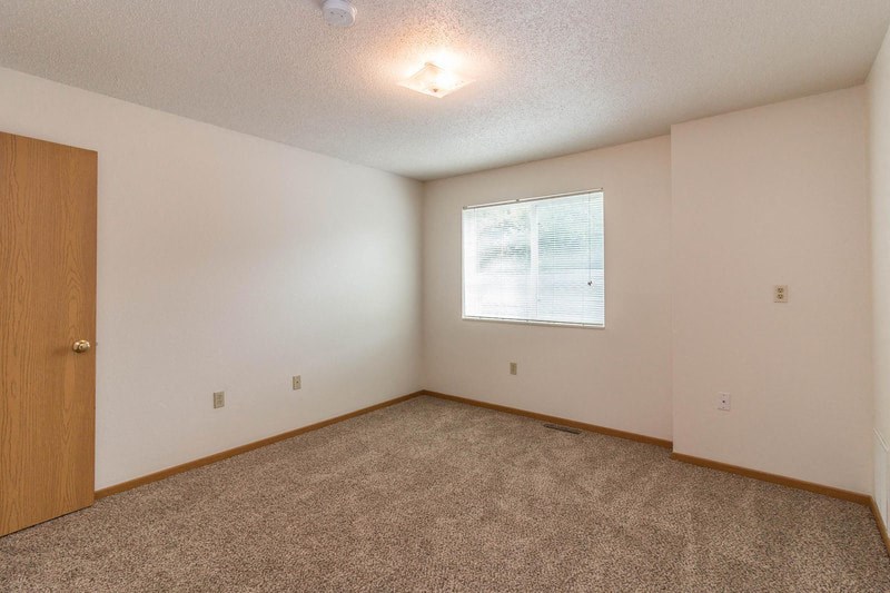 an empty room with carpet and a window