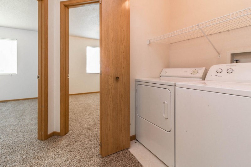 an empty laundry room with a washer and dryer in it