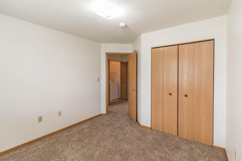 a bedroom with a closet and a door to a bathroom