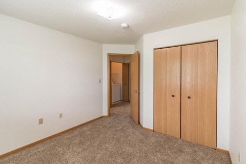 a bedroom with a closet and a door to a bathroom