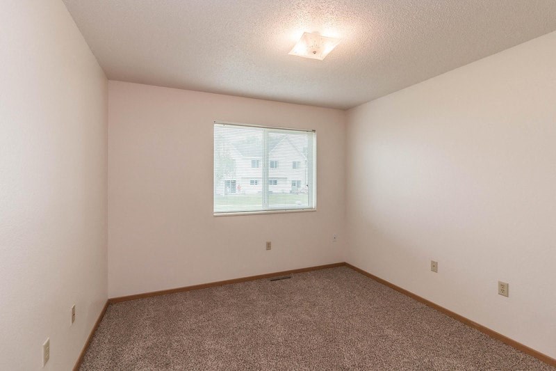 an empty room with carpet and a window
