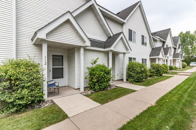a white house with a sidewalk in front of it