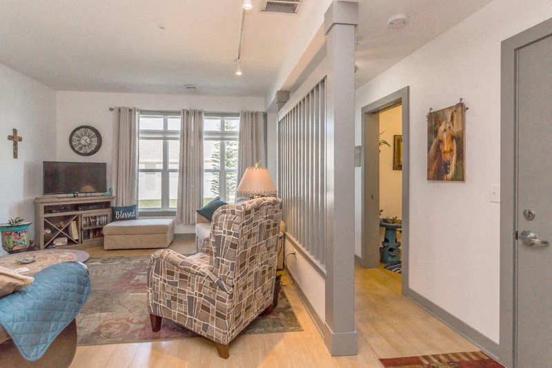 a living room with a couch and a chair and a door to a hallway