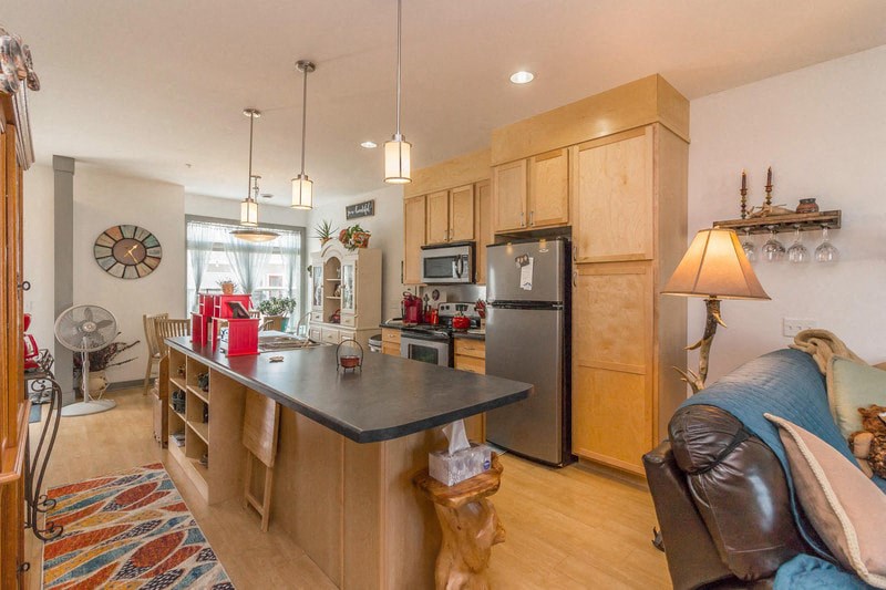 a kitchen with a center island and a stainless steel refrigerator