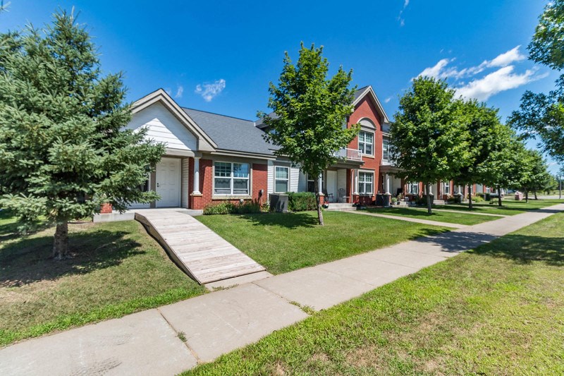 a brick house with a sidewalk in front of it