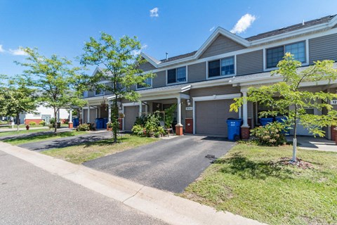 a house with a driveway and trees in front of it