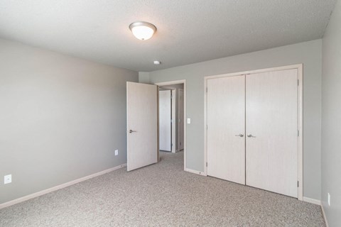 an empty bedroom with a closet and a door to the bathroom