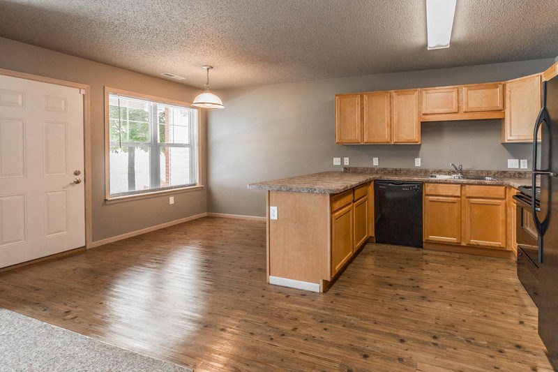 an empty kitchen with wooden floors and wood cabinets