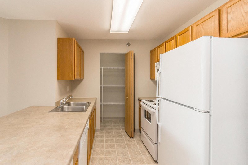 a kitchen with white appliances and a refrigerator and a sink