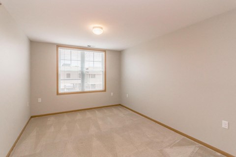 the living room of a home with a large window and a tiled floor