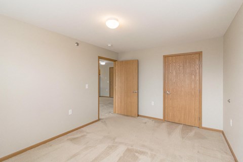 a bedroom with a door to a hallway and a closet