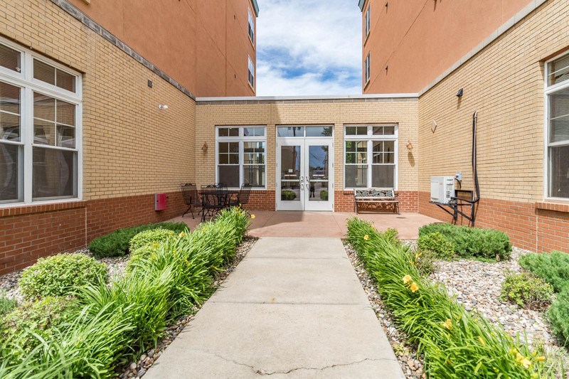 the courtyard of a brick building with a concrete walkway and benches