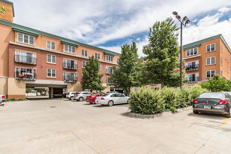 a parking lot with cars in front of an apartment building