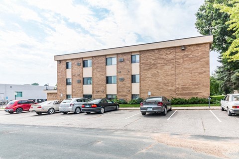 a large brick building with cars parked in a parking lot