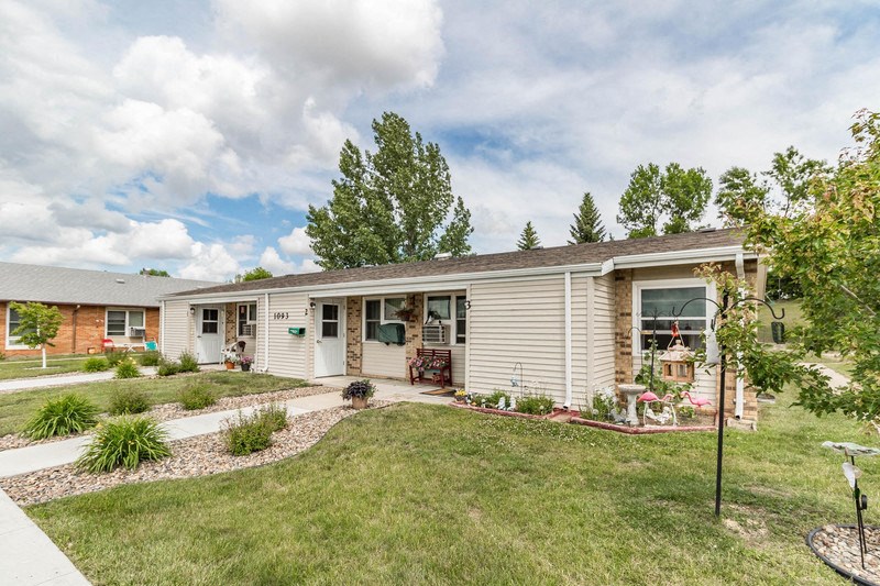 a small house with a lawn and a driveway