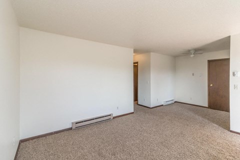an empty living room with white walls and carpet