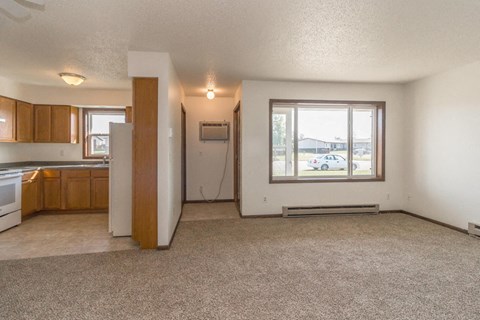 the living room and kitchen of an empty house with a window