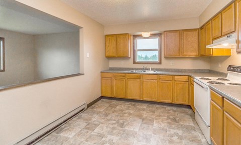 a kitchen with wooden cabinets and a stove and a sink