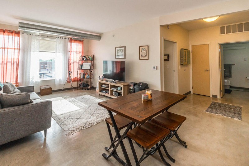 a living room with a wooden table and a television