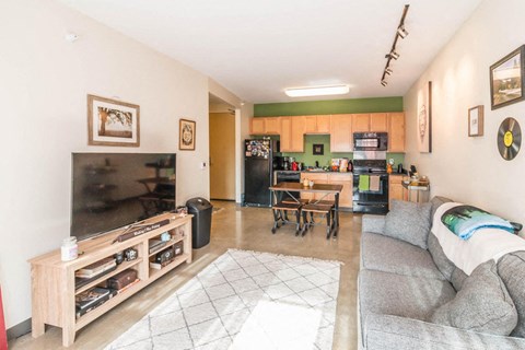 a living room and kitchen with a couch and a table