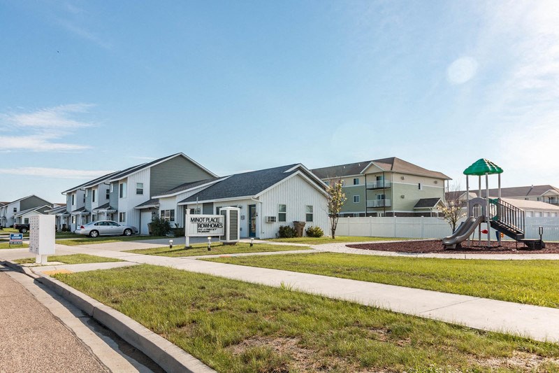 a group of houses with a playground in front of them