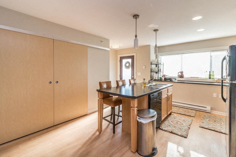 a kitchen with a black counter top and wooden cabinets