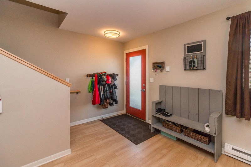 the entrance to a house with a closet and a red door