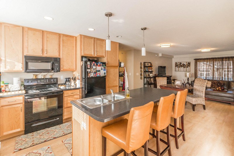 a kitchen with a bar and a living room