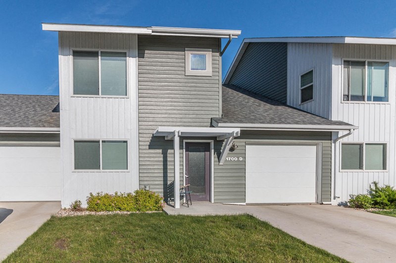 a gray and with a driveway and a garage door