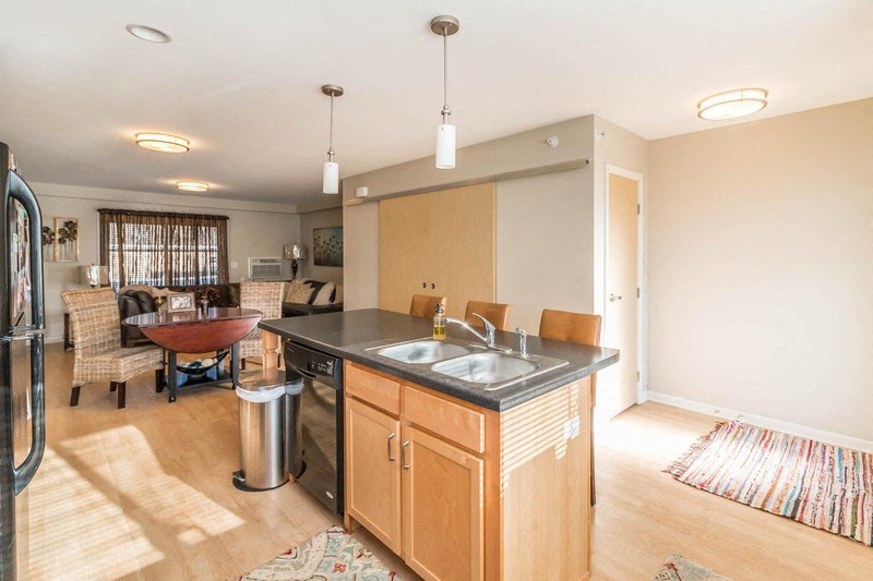 a kitchen with an island and a dining room with a table and chairs
