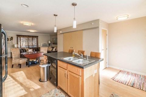 a kitchen with an island and a dining room with a table and chairs