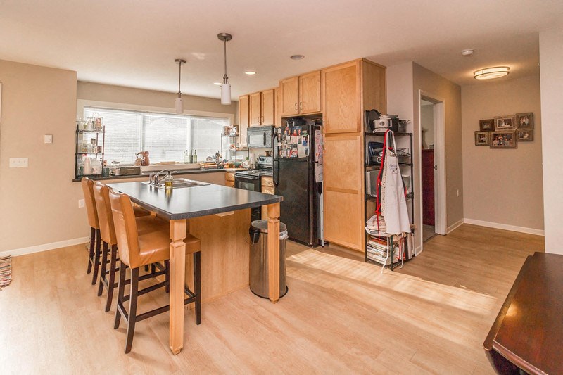 a kitchen with wooden cabinets and a table with chairs