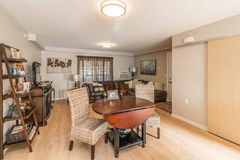 a living room and dining room with a table and chairs
