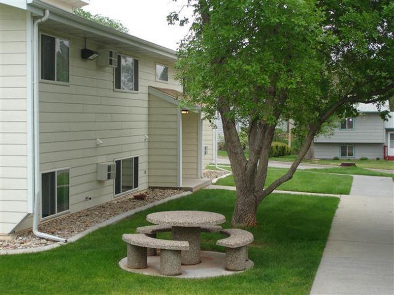 a group of stone picnic tables sitting in the grass