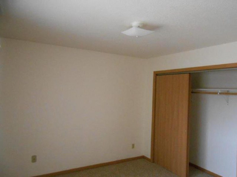 an empty room with a door to a closet