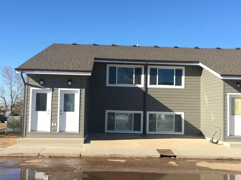 the front of a house with a blue sky in the background