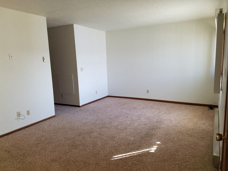 an empty room with a carpeted floor and white walls