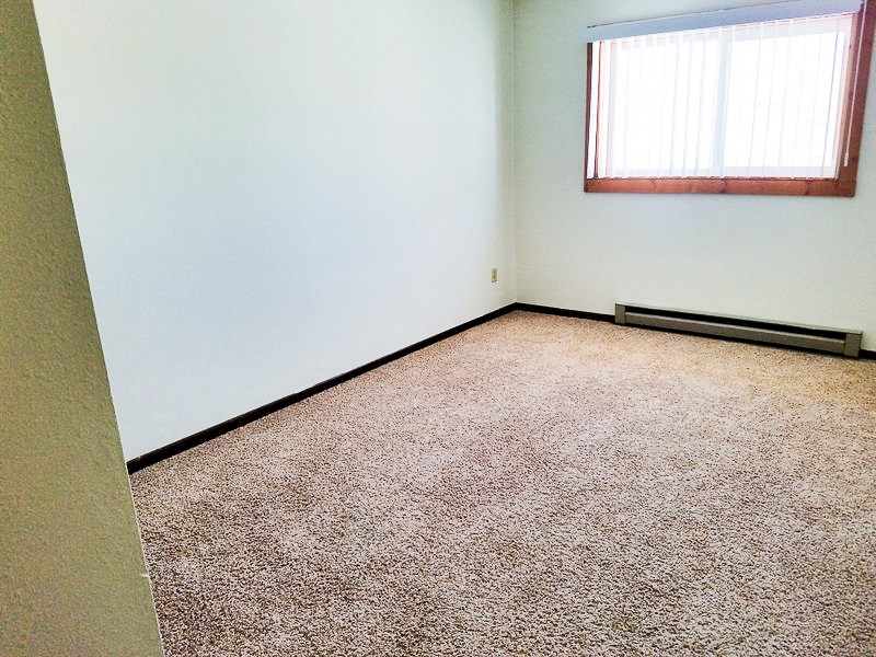 a room with a carpeted floor and a window